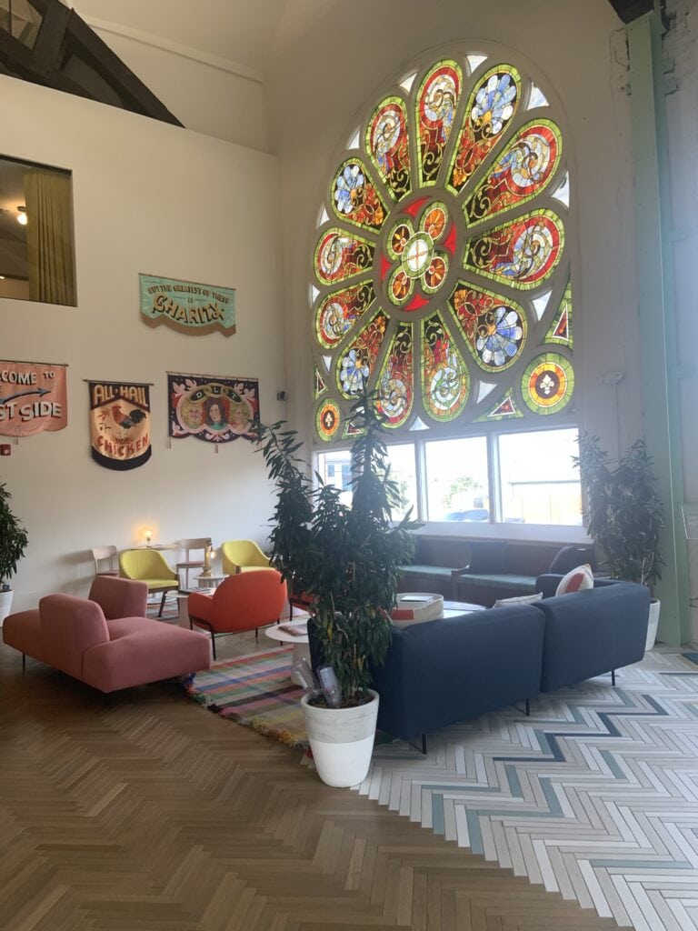 A view of the lobby with a large beautiful stained glass window at the Russell in Nashville.
