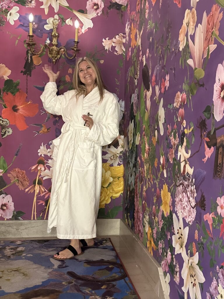 Bev in the stairwell covered in purple flowery wallcovinerg, Bev in a white robe at the 21c Museum Hotel St. Louis,