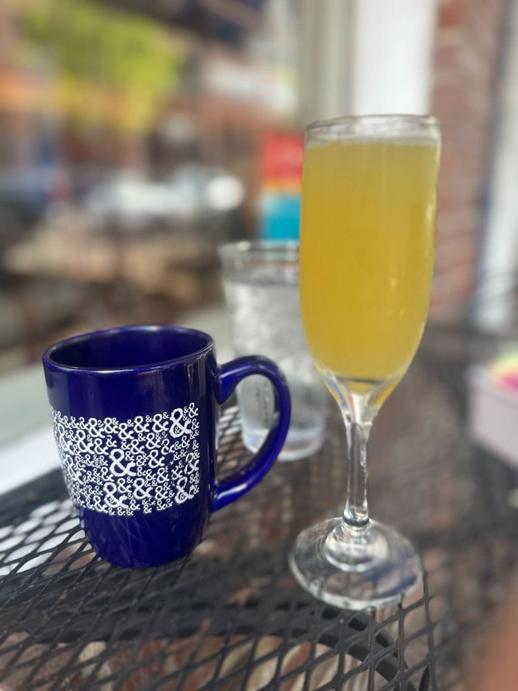 Coffee mug and mimosa on an outdoor table at Half & Half, a best breakfast in St Louis