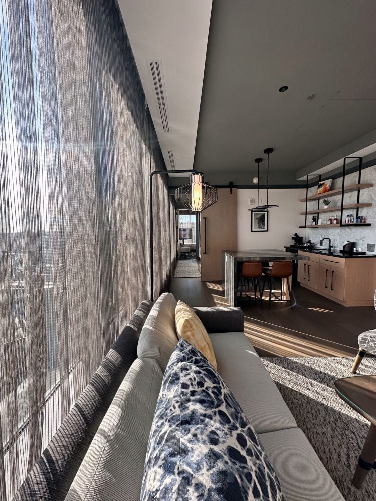 A view from the living room suite down the hallway to the corner bedroom, at The Farnam, an Omaha luxury hotel.