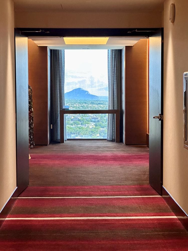 Hallway on a guest floor looking toward the window at the end of the hall, with a view of the mountain at Red Rock Casino and Hotel, one of the best Las Vegas hotels off the Strip.