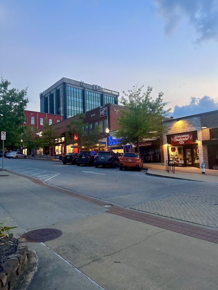 Downtown Fayetteville , Arkansas with a strip of shops and restaurants at dusk.