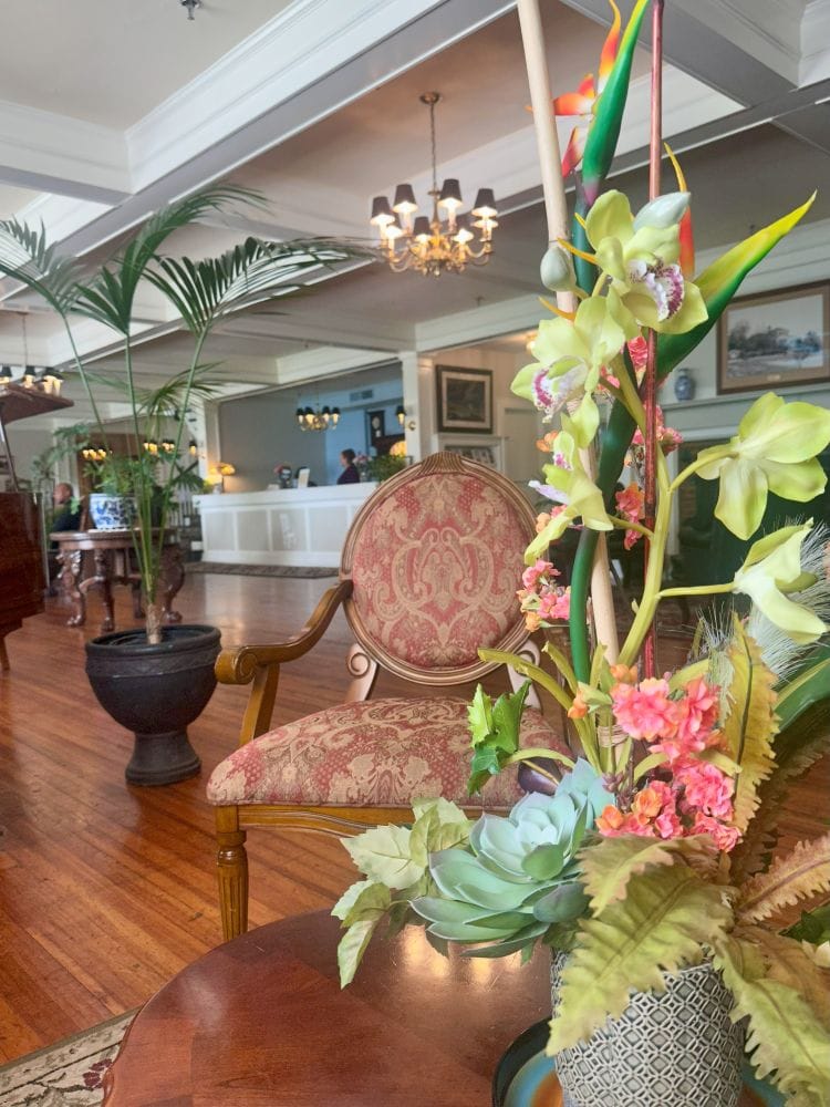 The lobby, looking at the guest desk with elaborate flowers in the foreground of the Lakeside Inn in historic Mount Dor.