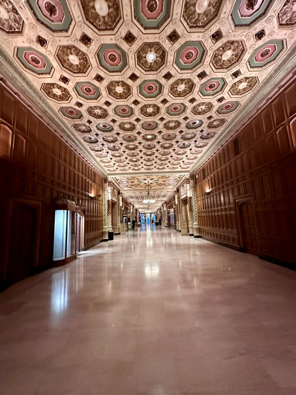 Looking down the grand hallway with the ornate fresco on the ceiling at the Biltmore, a haunted LA hotel.