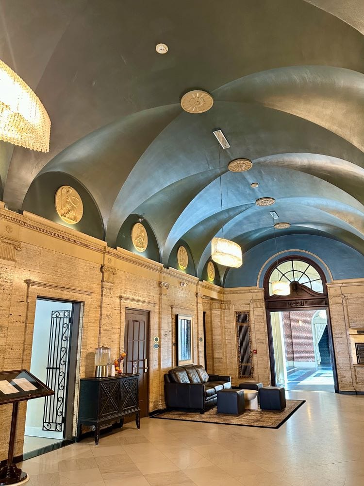 The teal domed ceiling and white marble walls in the lobby of the Magnolia Hotel, one of the best hotels in Omaha.