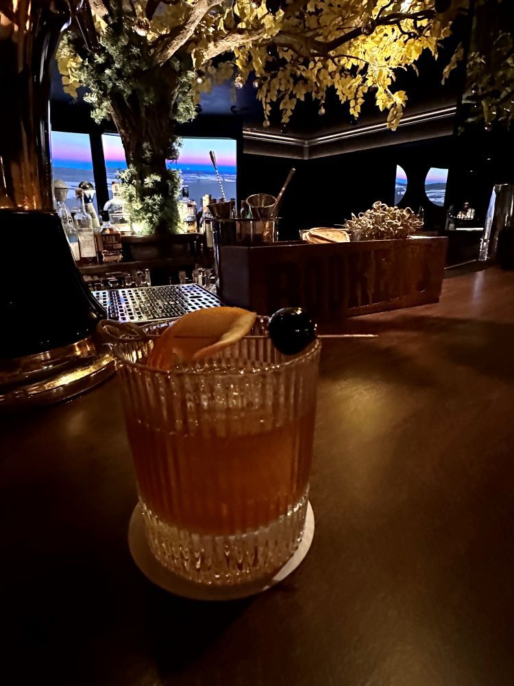 An Old Fashioned on the bar at The Cottonwood Room, a dark and moody cocktail bar at The Kimpton Cottonwood Hotel, one of the best hotels in Omaha.