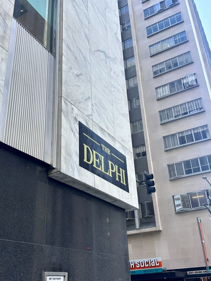 The exterior corner of The Dephi hotel with the logo on the building in black and gold, a boutique hotel downtown Los Angeles.