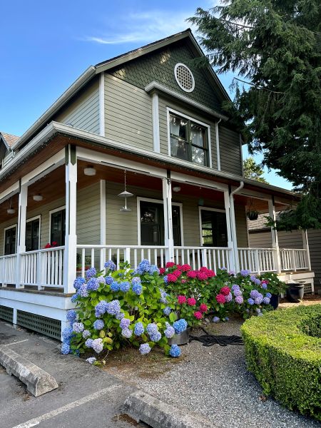 a cute exterior of Wild Iris Inn with porch and flowers.