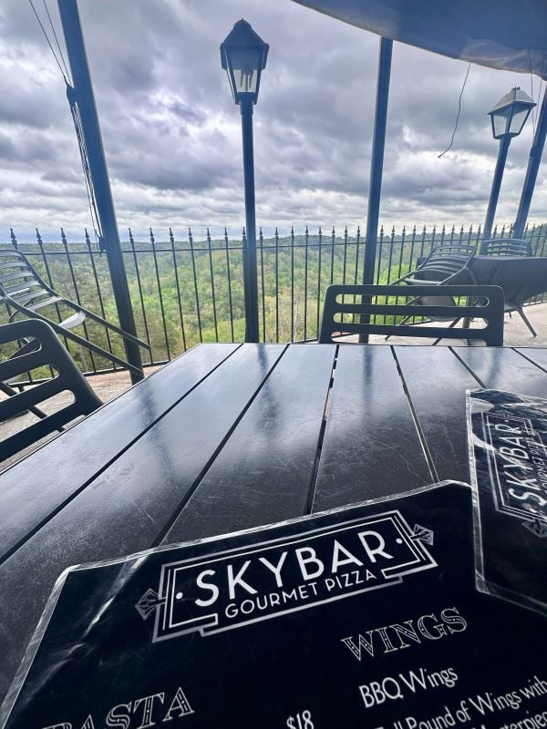 A view of the Skybar menu on the table with the view of the Ozark Mountains in the backgroud, from the rooftop bar & restaurant at The 1886 Crescent Hotel during our weekend in Eureka Springs.
