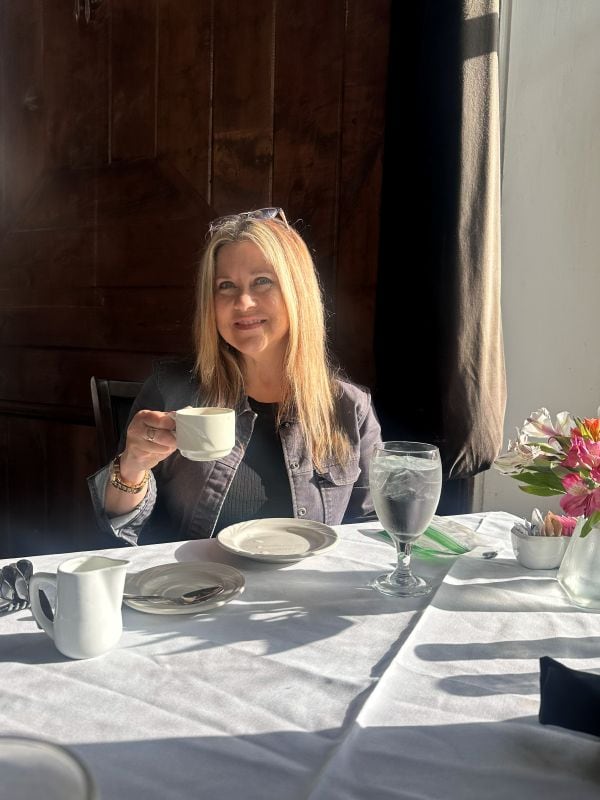 Me practicing my posing at the breakfast table, coffee mug in hand, next to the window at the 1886 Crescent Hotel Eureka Springs.
