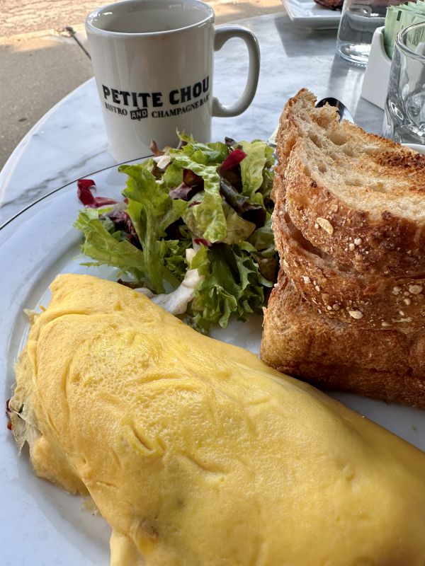 An omellette, side of greens and multi-grain toast at Petite Chou Bistro and Champagne bar, a local restaurant for breakfast.