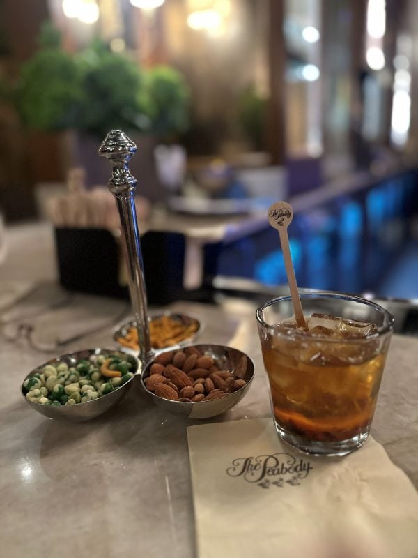 A cocktail on the bar with nuts at The Peabody Hotel Memphis on my Mississippi road trip.