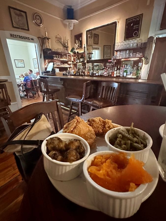 Southern comfort food plate with mashed sweet potatoes, fried chicken, and greens at Walnut Hills, a restaurant in Vicksburg, on my Mississippi road trip.