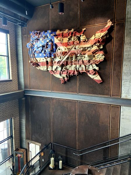 An American flag art on the wall made of industrial machine parts painted to look like a flag and in the shape of the US at the Ironworks Hotel, an industrial style hotel in Indianapolis.
