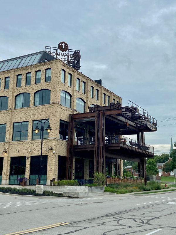 The exterior of the hotel, showing a rust colored steel structur that makes up the patio of Provision Restaurant and the private patios of certain rooms on the top floor at the Ironworks Hotel, an industrial style hotel in Indianapolis.