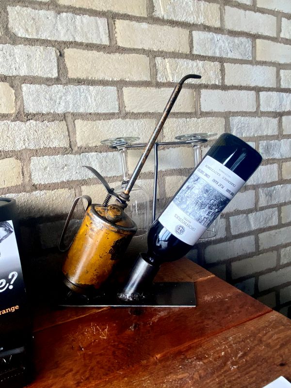 Upside down wine bottle in a wine stand made with an oil can in a guest room at the Ironworks hotel, an industrial style hotel in Indianapolis.