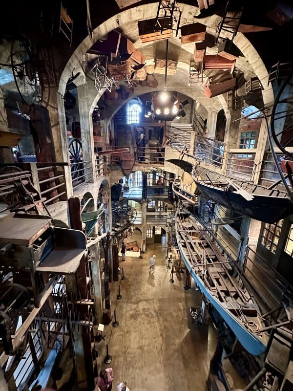 Looking in the cavern of the castle from the top floor with many arches, a boat and tools hanging, at the Mercer Museum, Philadephia off the beaten path.