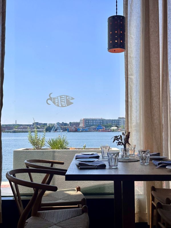 A table in the foreground a window looking into the harbor in the background at La Jette, best breakfast spots in baltimore.