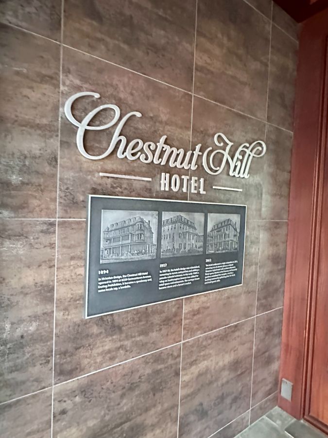 The entrance with the sign and three old pictures of the hotel at Chestnut Hill Hotel Philadelphia.