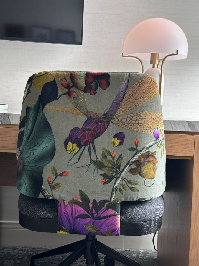 A floral desk chair at the desk in a guest room at the Kimpton Monaco, a hotel near Independence Hall.