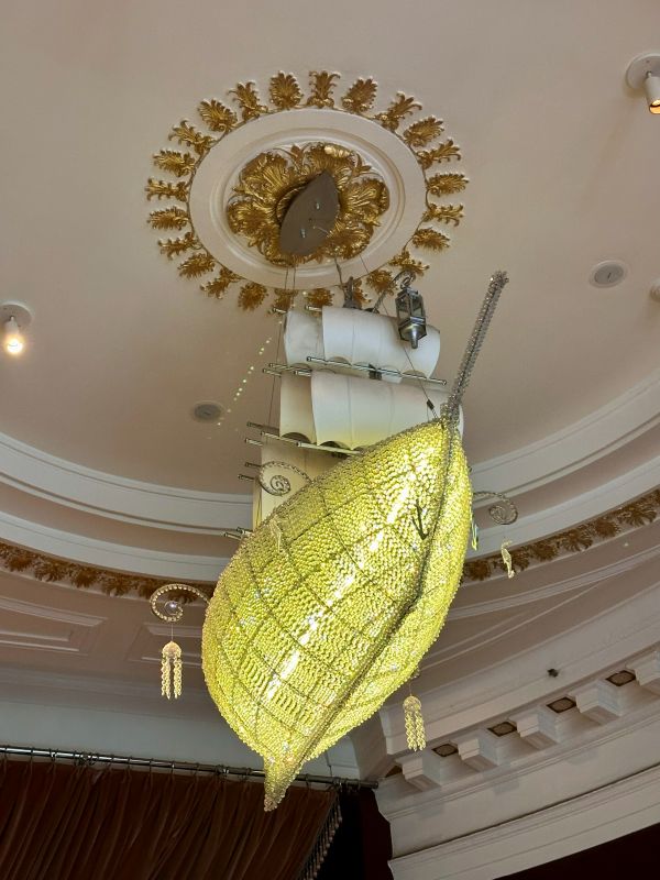 A yellow sail boat chandelier hanging in the lobby of the Kimpton Monaco, a hotel near Independence Hall.