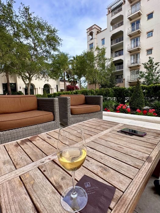A glass of wine on a table in the courtyard at The Alfond Inn in Winter Park Florida.
