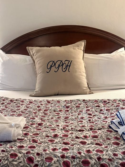 I monogram pillow on a bed with a flower bedspread at the Park Plaza Hotel in Winter Park Florida.