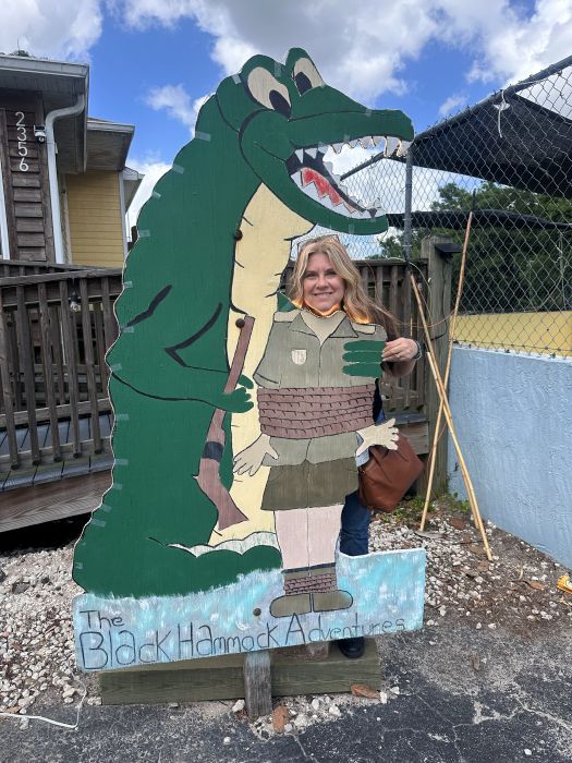 A gator cutout photo op with me, Bev with my head in the cutout next to the aligator at Lazy Gator Bar.