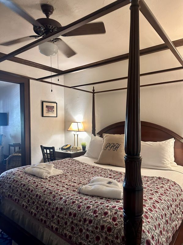 A four poster bed with a red flower quilt at the Park Plaza Hotel, a Winter Park Florida Hotel.
