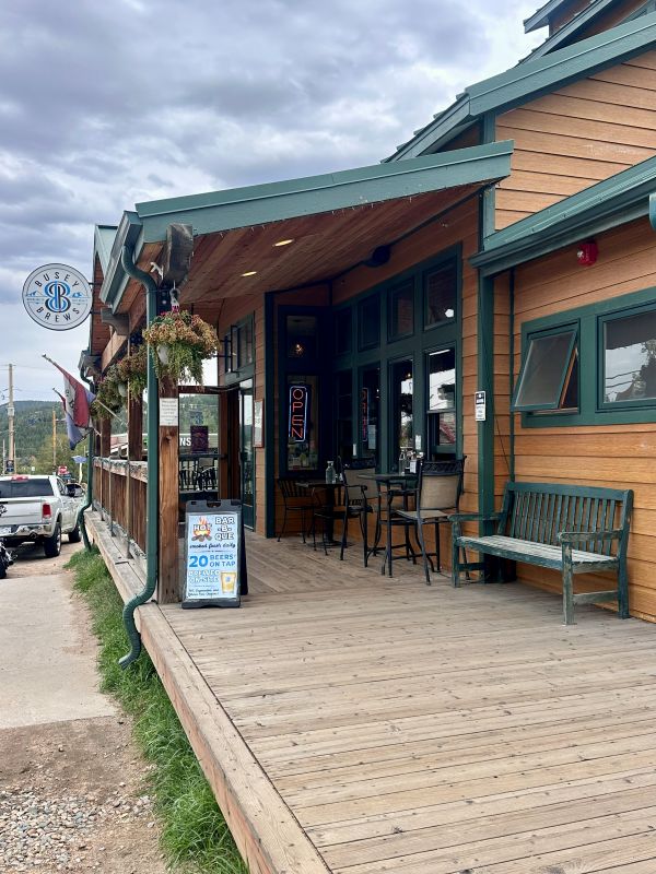 The exterior of Busey Brews in Nederaland, wood plank porch, and sign hanging from porch overhang in Nederland on our Colorado mountain retreat.