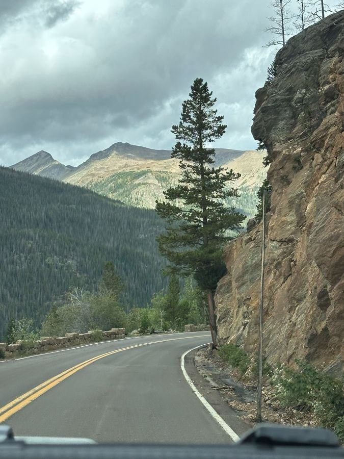 A cliff on the right and the road and mountains on the left at Rocky Mountain National Park on my Colorado mountain retreat.
