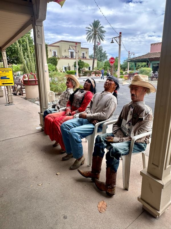 Vintage cowboy statues sitting on a porch in Old Town Scottsdale, Arizona.