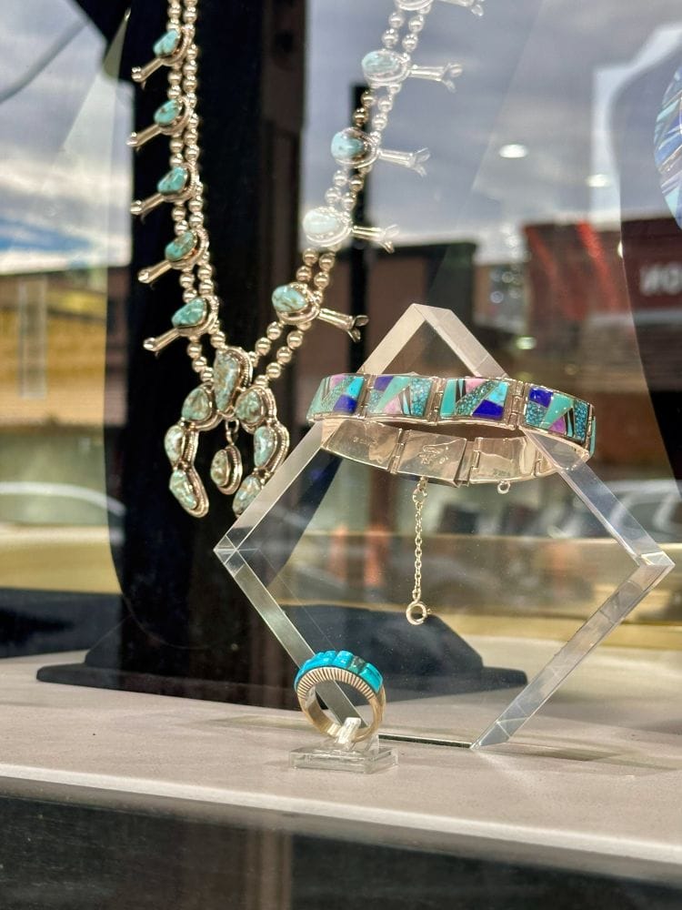 Jewelry display with necklaces, bracelets, and rings in an Old Town Scottsdale shop window.