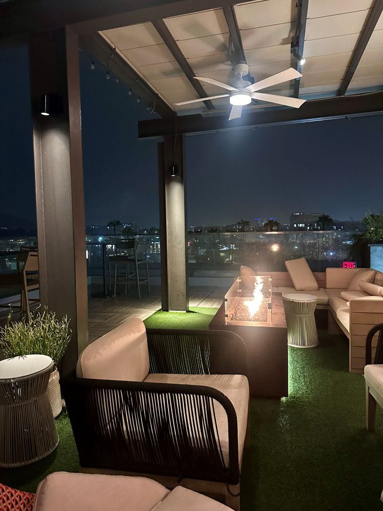 Nighttime rooftop lounge with seating and city view at The Outsider Rooftop Lounge in Scottsdale, Arizona.