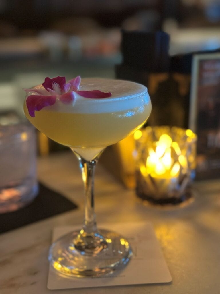 Delicious cocktail with flower garnish on a bar table at The Beverly in Old Town Scottsdale, Arizona,