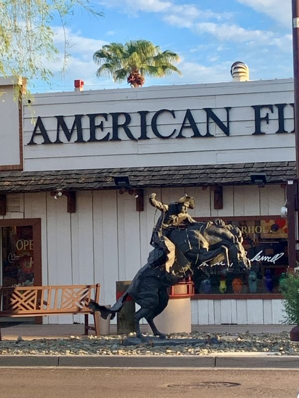 Bronze horse and cowboy sculpture outside American Fitters store in Old Town Scottsdale Arizona.