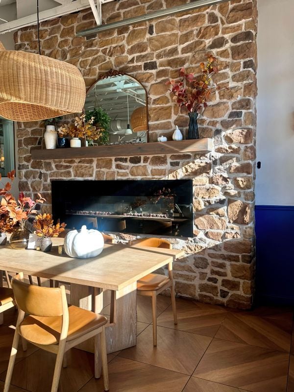 Charming sitting rea with stone fireplace, wooden furniture, and decorative accents at JoJo Coffeehouse in Scottsdale, Arizona.