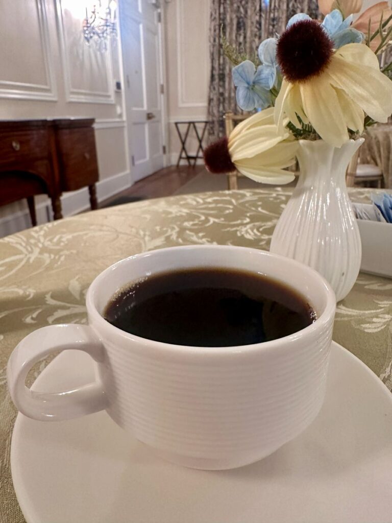 Coffee and flowers on a table in the dining room at the Duke Mansion