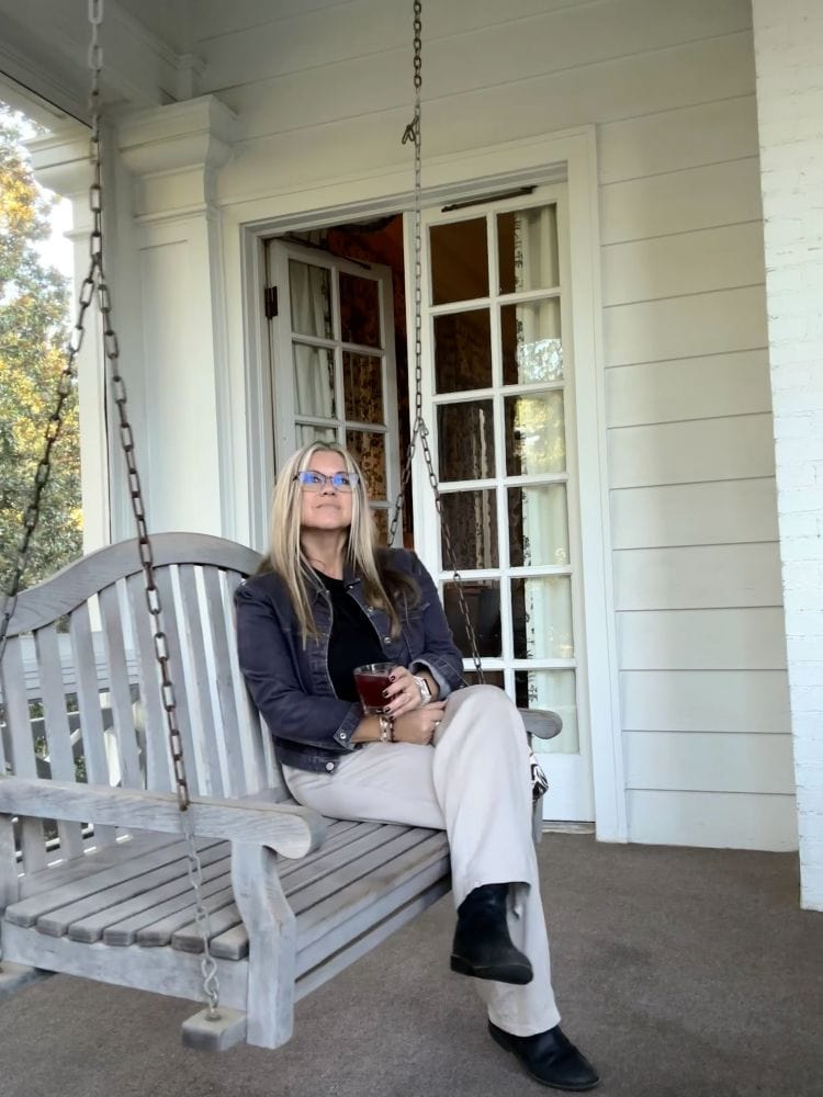 Bev sitting on the swing outside her room on the second floor at the Duke Mansion, one of the historic hotels in Charlotte.
