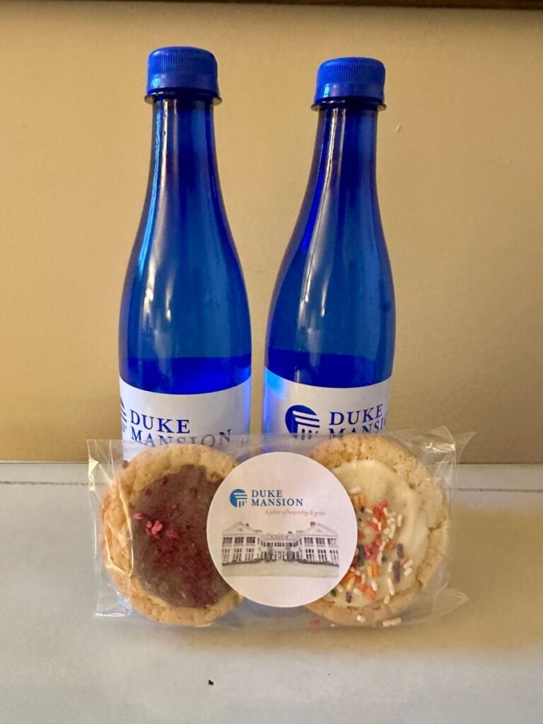 Two blue water bottles and cookies in the guet room at the Duke Mansion.