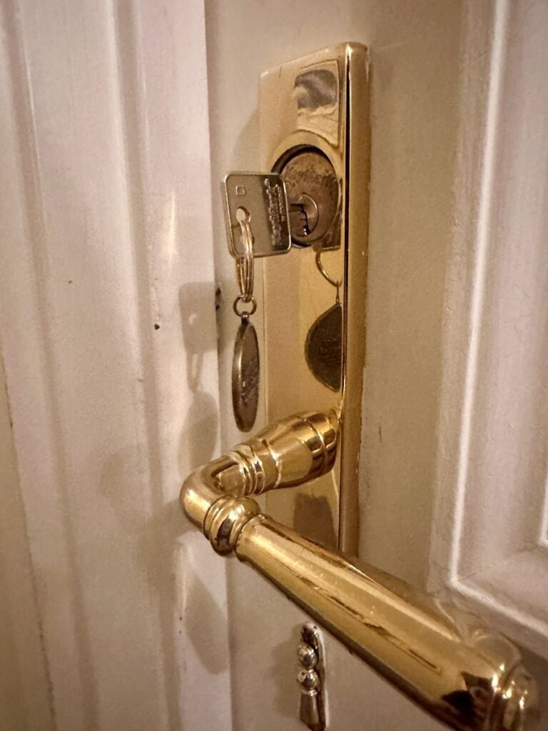A real key in the brass door lock to a guest room at the Duke Mansion, one of the historic hotels in Charlotte.