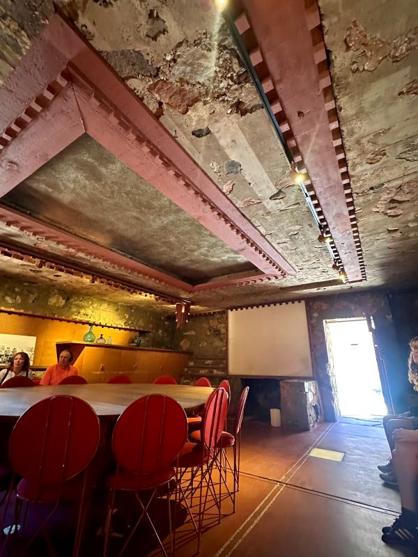 Interior of a rustic meeting room at Taliesen West, a Frank Lloyd Wright home, with exposed brick ceiling and vintage decor.